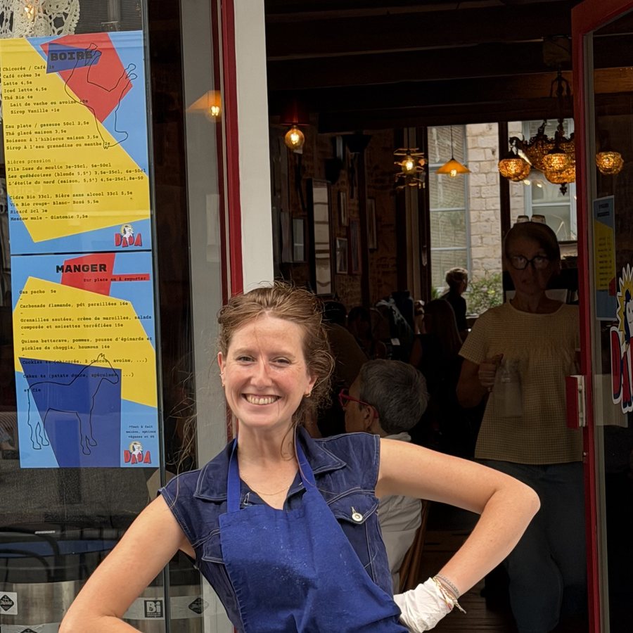Carole en tablier bleu à la porte de DADA