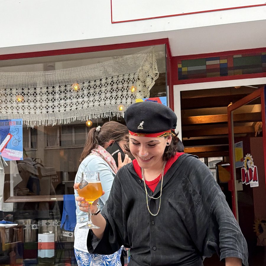 Julie, bière à la main, devant la vitrine